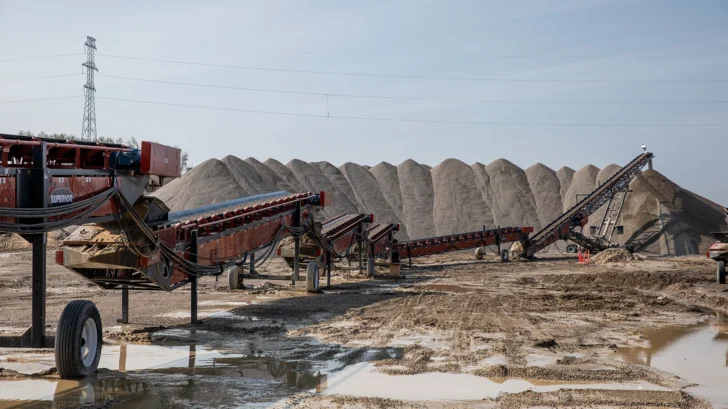 Conveyor system transferring material between stockpiles