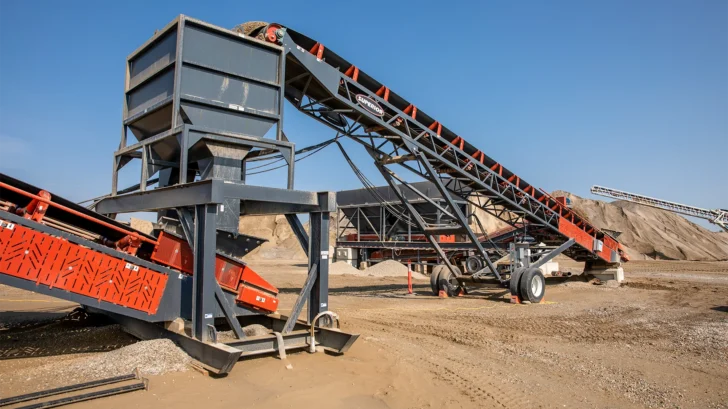 Superior feed hopper receiving material beneath a conveyor structure