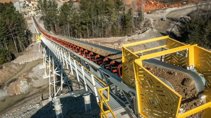 Conveyor transferring material across quarry terrain