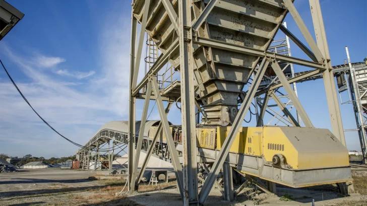 Superior Stationary Feed Hopper installed in a fixed aggregate processing plant with conveyors and support structure.