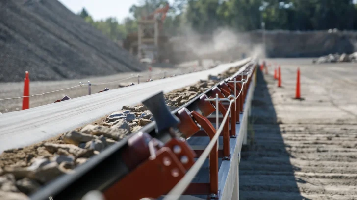 Aggregate material traveling on a long-distance conveyor belt
