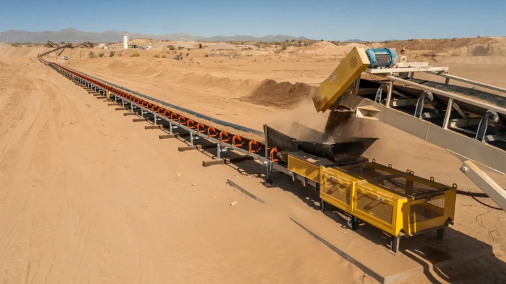 Conveyor transfer point feeding material onto an overland system