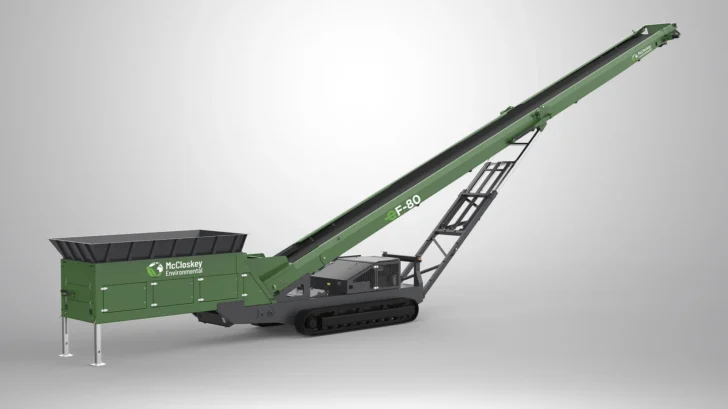 Angled view of the Feeder Stacker with hydraulic folding head section, crawler tracks, feeder hopper, and raised conveyor.