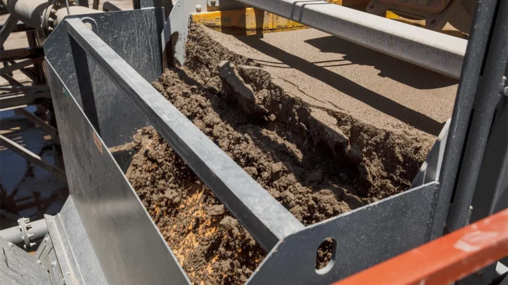 Dewatering screen discharge showing wet aggregate material